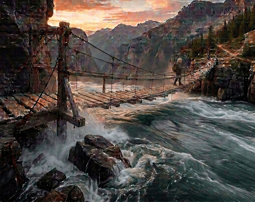 Hiker crossing a suspension bridge above a mountain gorge